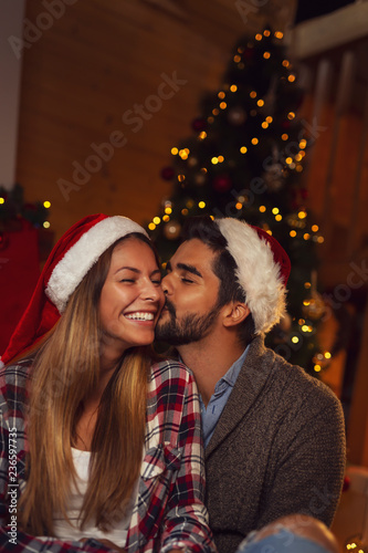 Couple kissing by the Christmas tree