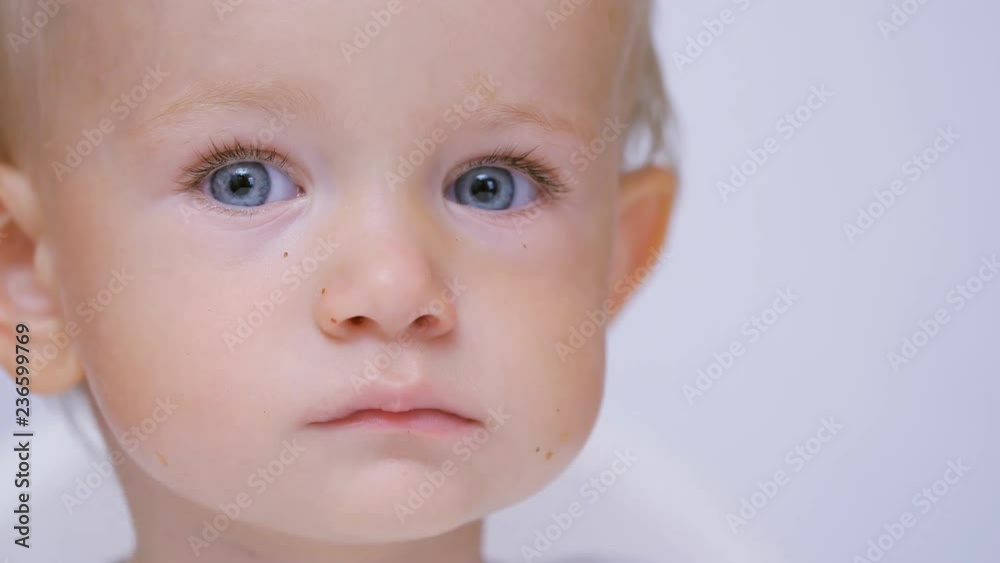 Serious baby portrait, blond child with blue eyes Serious baby portrait, blond child with blue eyes