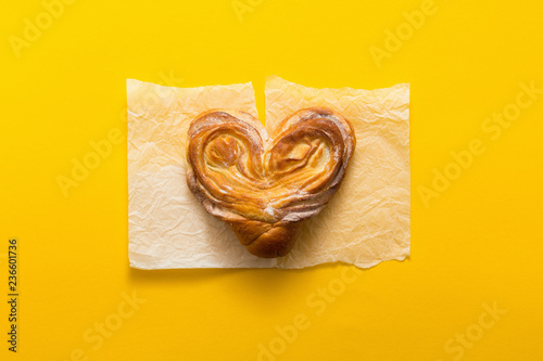 Sweet bun on yellow background, tiop view, flat lay