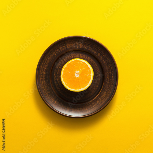 Orange fruit slice on yellow background, top view, flat lay
