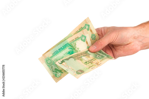 Hand holding dirhams banknotes of United Arab Emirates isolated on white background