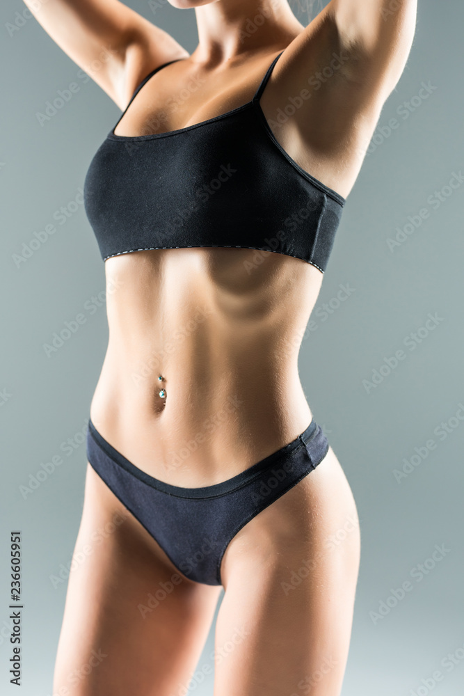 Beautiful slim body of woman in lingerie isolated on gray background