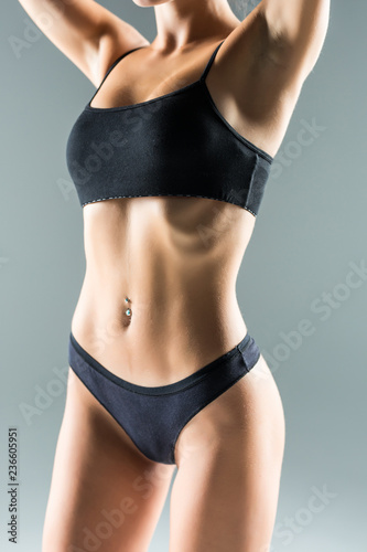 Beautiful slim body of woman in lingerie isolated on gray background © dianagrytsku