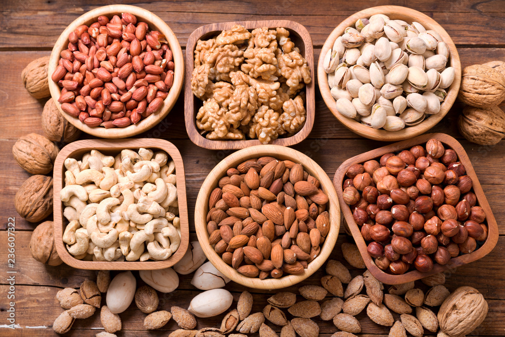 bowls of nuts on wooden table, top view bowls of nuts on wooden table, top view