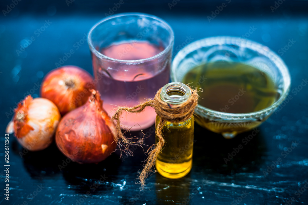 Close up of best hair therapy on wooden surface . onion juice well mixed  with organic olive  boosts hair growth and fights dandruff and  condition your hair and scalp. Stock Photo |
