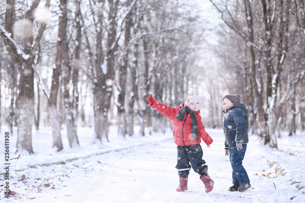 Naklejka premium Kids walk in the park first snow