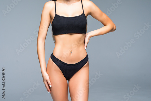 Cropped shot of fit woman s torso woman in bikini isolated on white background.