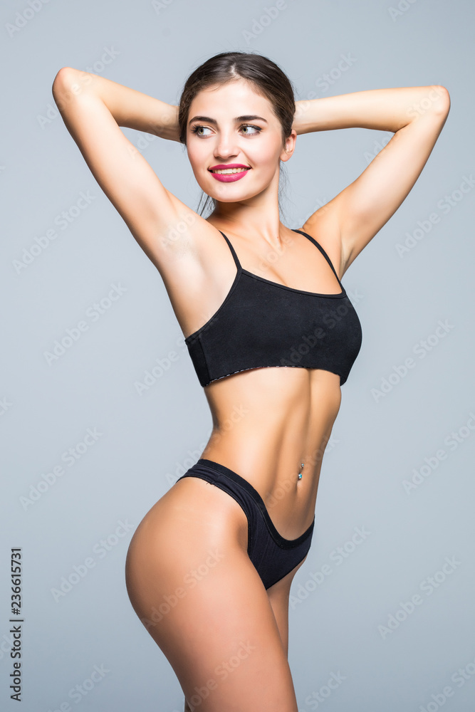 Fitness perfect woman with a beautiful body in black lingerie isolated on gray background Fitness perfect woman with a beautiful body in black lingerie isolated on gray background