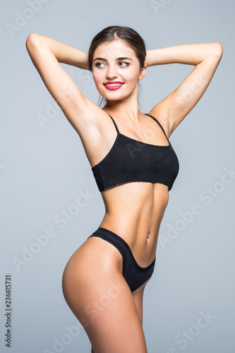 Fitness perfect woman with a beautiful body in black lingerie isolated on gray background © dianagrytsku