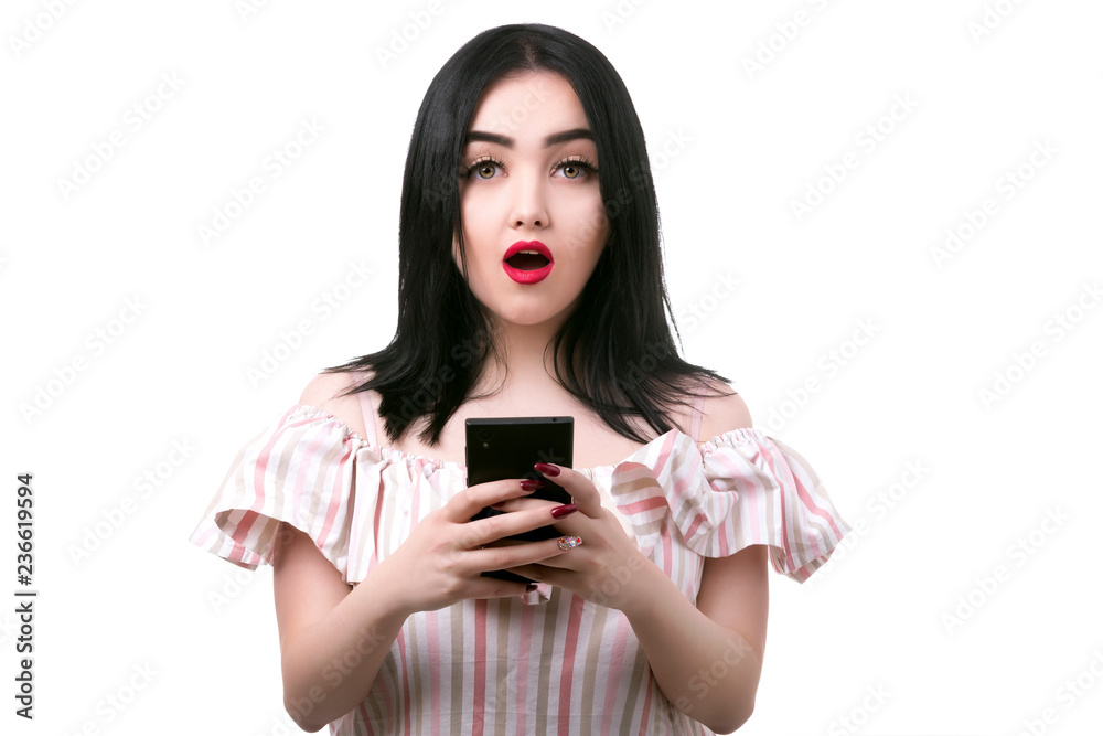 plus size model with mobile phone in hand looking at camera in surprise plus size model with mobile phone in hand looking at camera in surprise