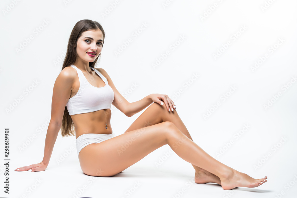 People, beauty, epilation and bodycare concept. beautiful woman with sexy legs sitting on floor over white background