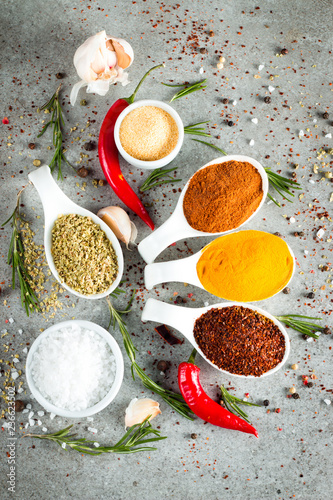 Spices in Wooden spoon. Herbs. Curry, Saffron, turmeric, rosemary, cinnamon, garlic, pepper, anise on wooden rustic background. Collection of spices and herbs. Salt, paprika. 