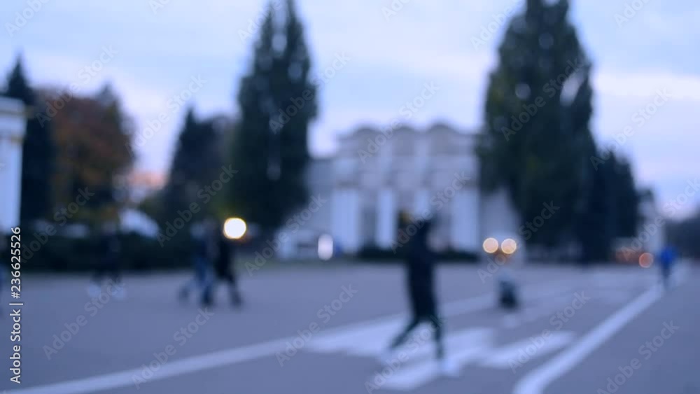 Many people walk by city square. People walking slowly relax on the town. Blurred Background of city or town. Beautiful abstract urban backdrop. Many people walk by city square. People walking slowly relax on the town. Blurred Background of city or town. Beautiful abstract urban backdrop.