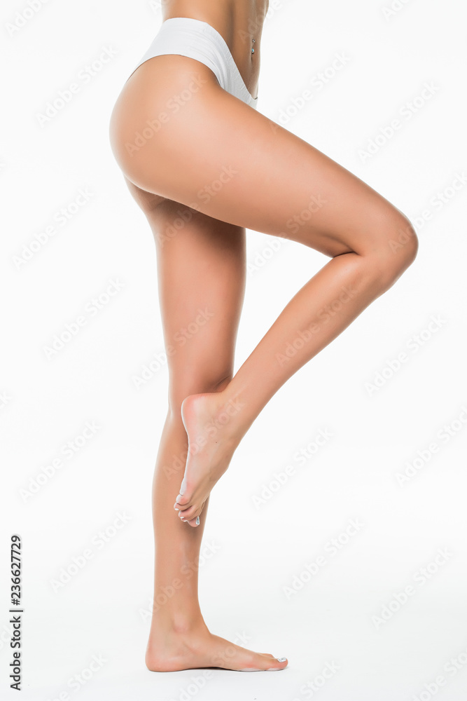 Fit and beautiful female body. Young girl in white swimsuit isolated on white background Fit and beautiful female body. Young girl in white swimsuit isolated on white background