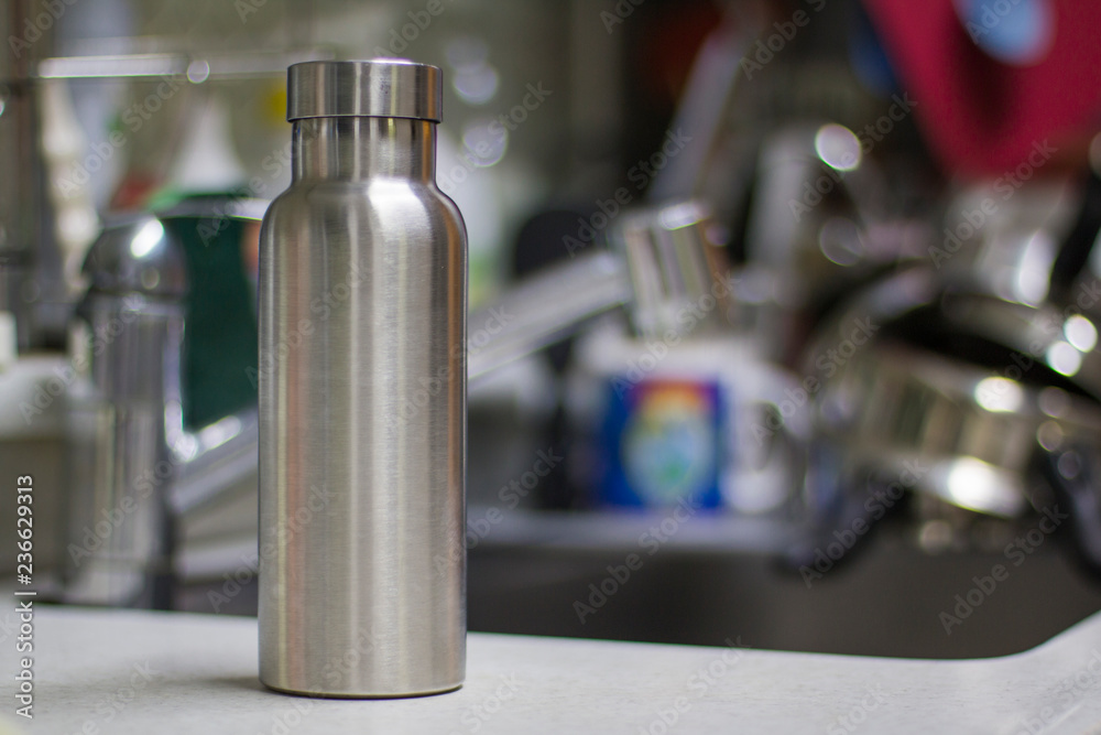Insulated Stainless Bottle with utensils and sink kitchen background Insulated Stainless Bottle with utensils and sink kitchen background