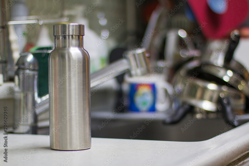 Insulated Stainless Bottle with utensils and sink kitchen background Insulated Stainless Bottle with utensils and sink kitchen background