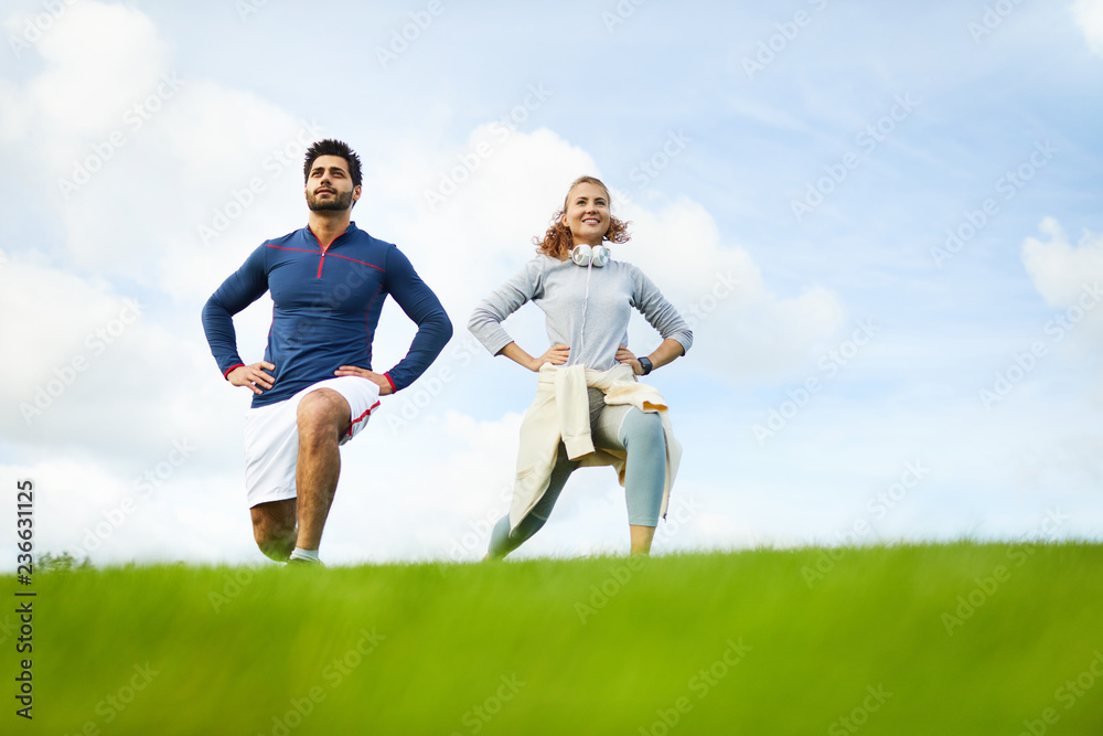 Happy young sporty woman and man enjoying their morning workout in natural environment Happy young sporty woman and man enjoying their morning workout in natural environment