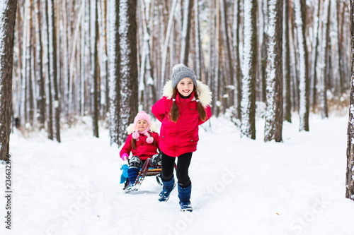 little girls playing on winter winter holidays in a winter forest