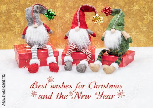 Weihnachtliche Grußkarte mit Wicheln sitzend auf Geschenken und Dekoration 