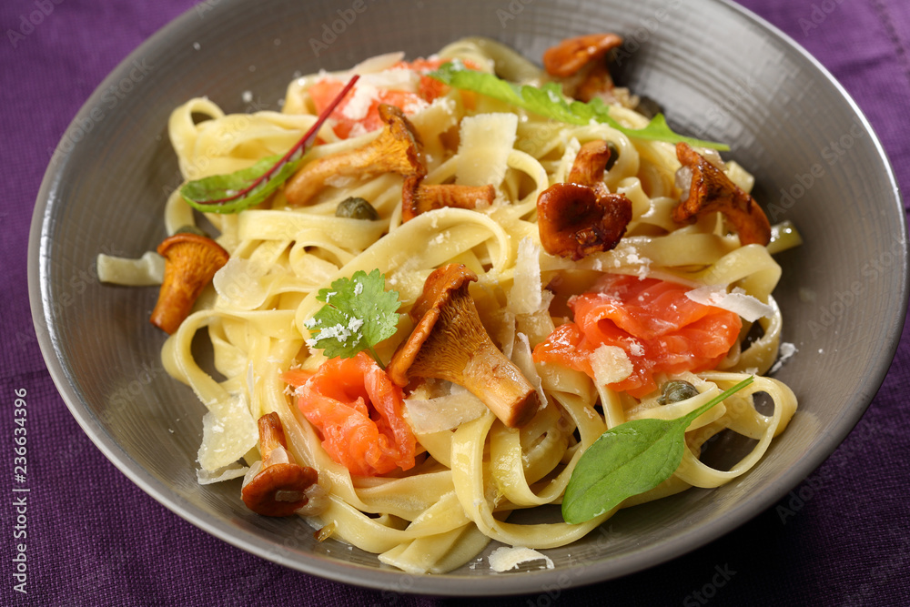 Tasty pasta with salmon and chanterelles mushrooms Tasty pasta with salmon and chanterelles mushrooms