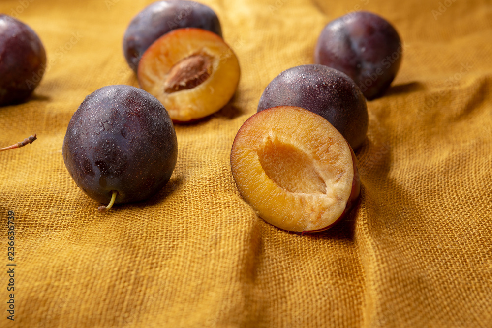 Fototapeta premium Organic plums on linen background
