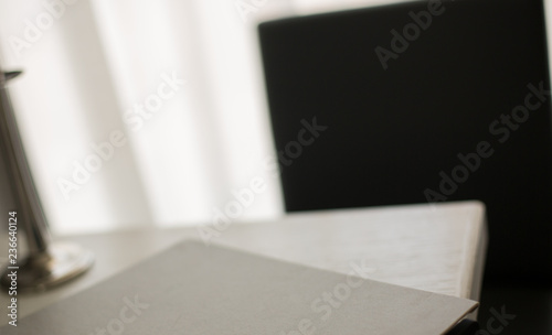 Room interior. Black chair and folder on a white table