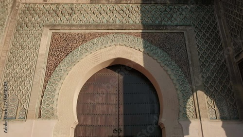 Camera tilt down push in forward view from top of Bab Mansour Gate wooden door in Meknes, Morocco