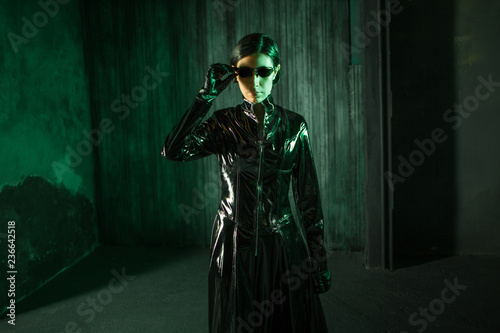 Girl hacker in the digital world. Young woman in matrix style suit.