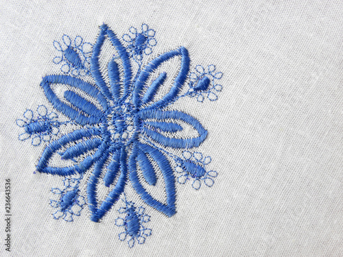 embroidered blue flower on white fabric
