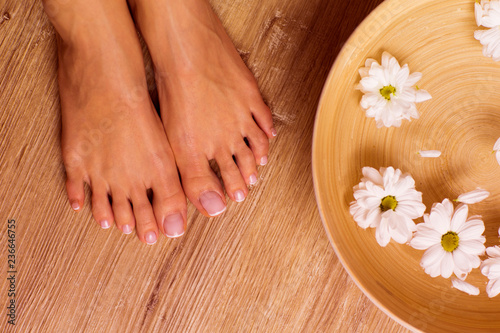 The picture of ideal done manicure and pedicure. Female hands and legs in the spa spot.