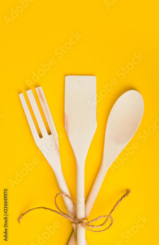Natural wooden cooking kit on yellow background. Organic food concept.