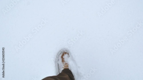 man walks in big winter boots steps on clean untouched white snow. only foot visible. closeup pov 4k footage