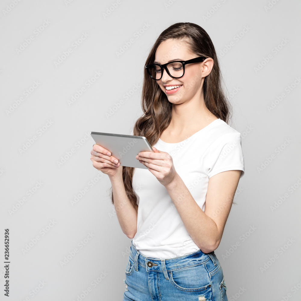 Portrait of happy female student wearing glasses, using digital tablet Portrait of happy female student wearing glasses, using digital tablet