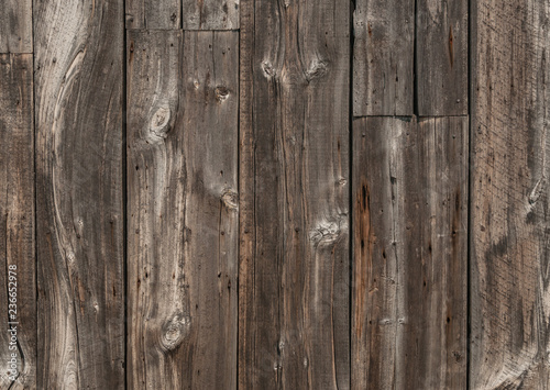 Old weathered wood plank siding with lots of texture from grain, knots, and nail holes.