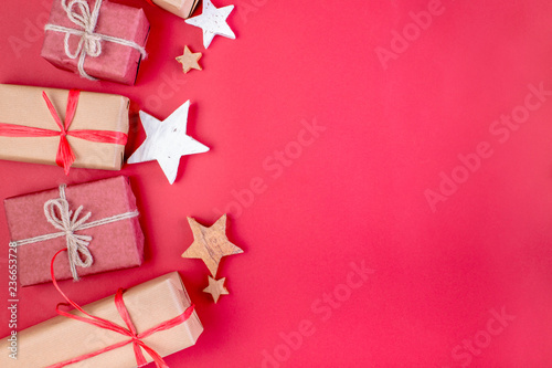 Christmas composition. Christmas red decorations, stars and gift boxes on red background. Flat lay, top view, space for the text