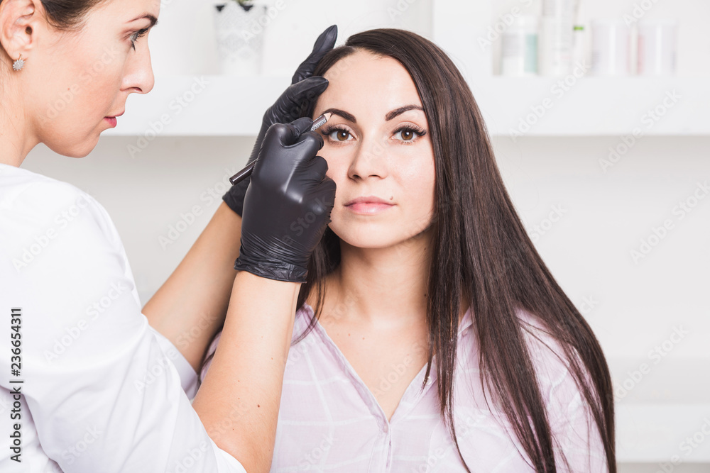 Permanent makeup for eyebrows of beautiful young woman in beauty salon Permanent makeup for eyebrows of beautiful young woman in beauty salon