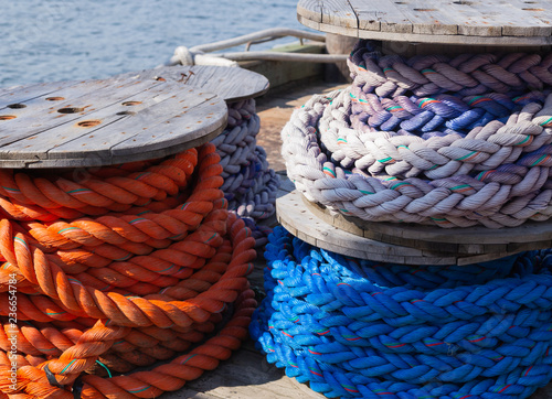 Spools of brightly coloured nautical rope stacked on a wharf.