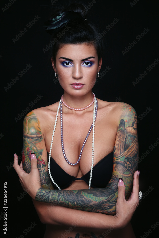 Young beautiful sexy tanned brunette with gorgeous tattoos on her arms  Stock Photo | Adobe Stock