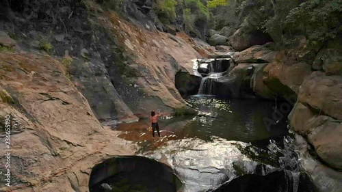 Very tranquil set of aerial footage showing a woman at a small waterfall in Australia. photo