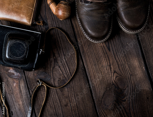 pair of leather brown shoes and an old vintage camera in a case
