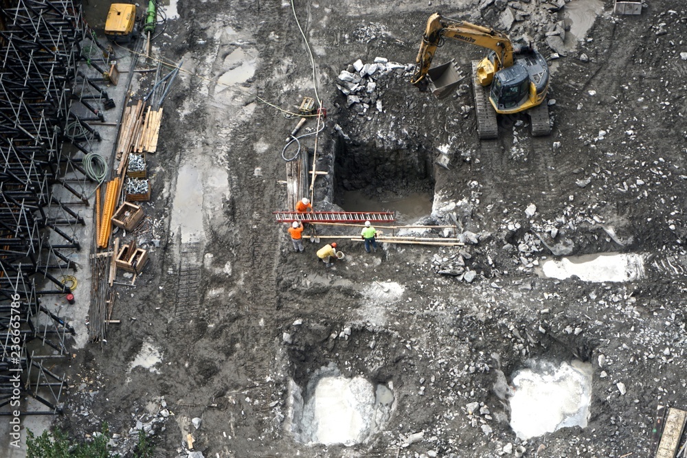 New York, New York, USA: Workers encounter water in holes cut into the Manhattan schist bedrock as construction begins on a high-rise apartment building in midtown Manhattan.