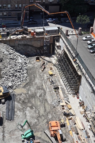 Photography New York City, New York, USA: Workers use a cement mixer with a long arm to construct a retaining wall as construction begins on a high-rise apartment building in Manhattan