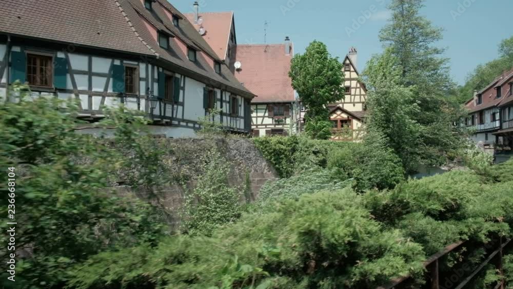 Camera forward push-in along La Weiss river along old town waterfront half-timbered houses in picturesque Kaysersberg village, France Camera forward push-in along La Weiss river along old town waterfront half-timbered houses in picturesque Kaysersberg village, France