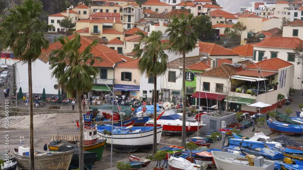 View of Câmara de Lobos in Madeira with Cape Girão on the background and boats at the marina