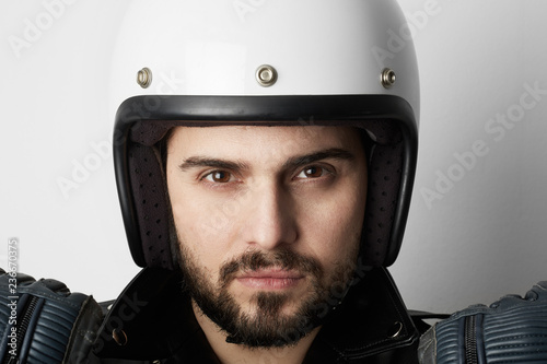 Close up portrait of smiling motorcyclist wearing helmet and leather jacket