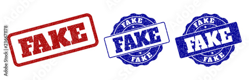 FAKE grunge stamp seals in red and blue colors. Vector FAKE labels with grunge surface. Graphic elements are rounded rectangles, rosettes, circles and text labels.