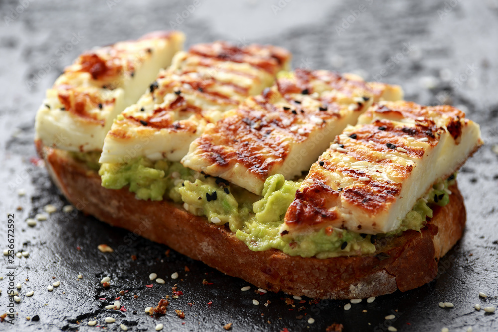 Avocado and grilled haloumi cheese toast with nigella and sesame seeds. healthy breakfast