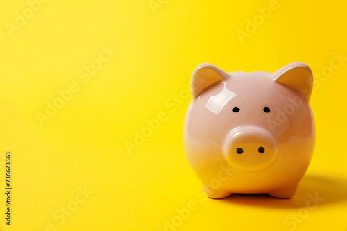 Photos Pink piggy bank isolated on yellow colourful trendy modern fashion background