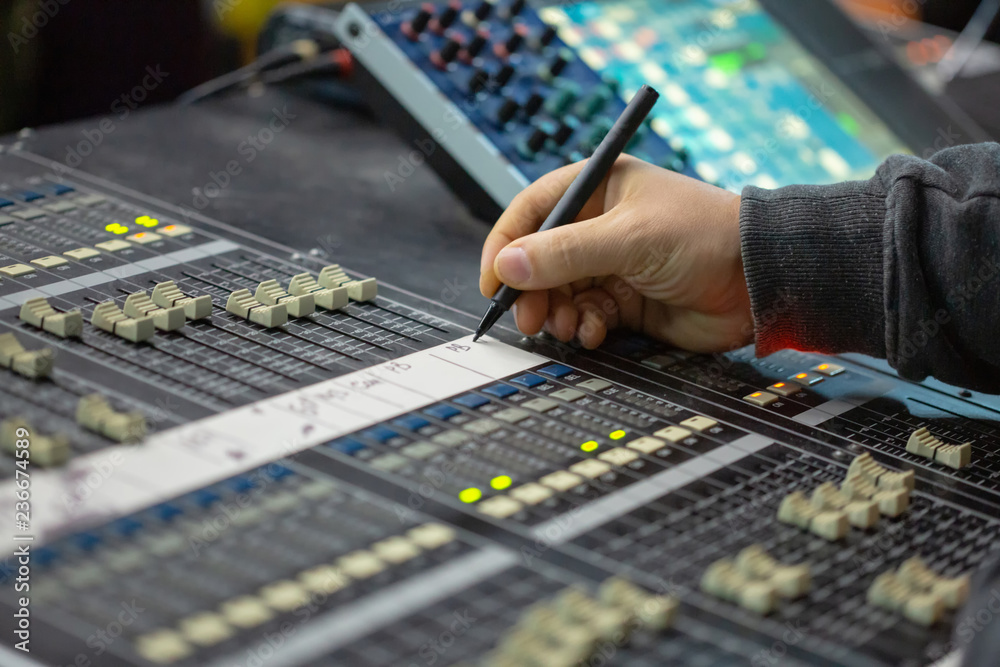 Soundman working on the mixing console. Soundman working on the mixing console.