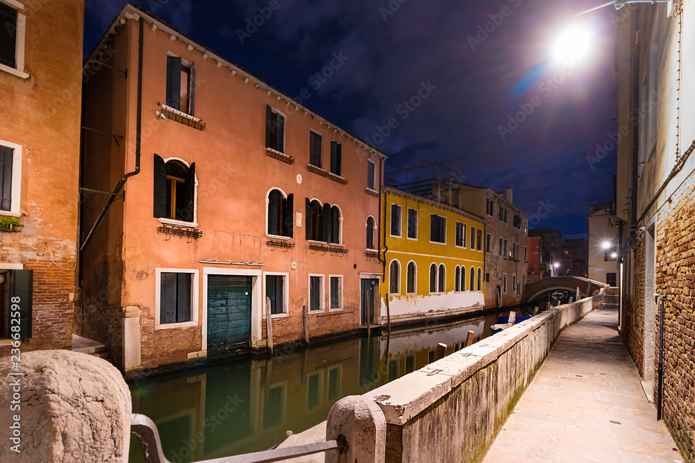 Sidewalk on a narrow canal - street in Venice at night, Italy. Sidewalk on a narrow canal - street in Venice at night, Italy.